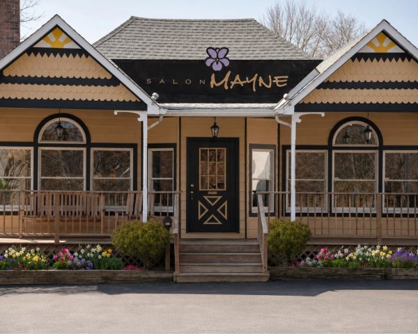 Exterior of Salon Mayne with flower beds.