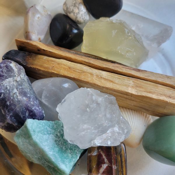 A collection of various crystals and two wooden sticks.