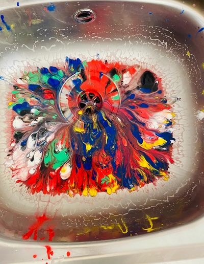Colorful paint swirl in a sink.