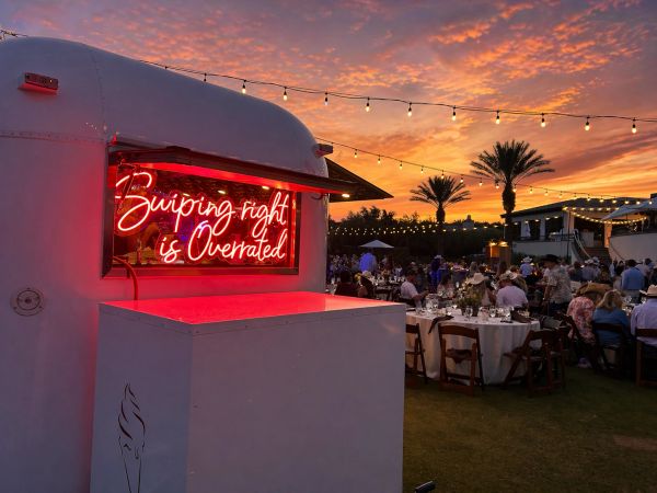Neon sign at outdoor evening event.