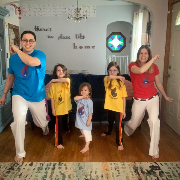 Family practicing martial arts together in their living room.