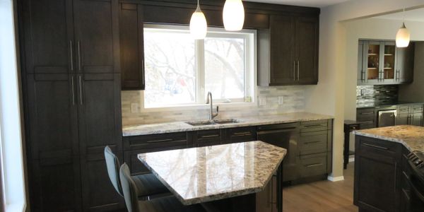 Newly renovated kitchen, dark coloured cabinets with granite counter top. 
