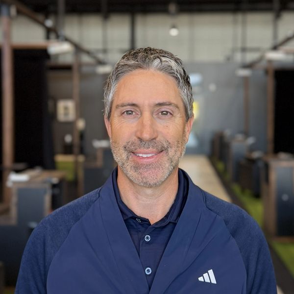 Smiling man with gray hair in a casual indoor setting.