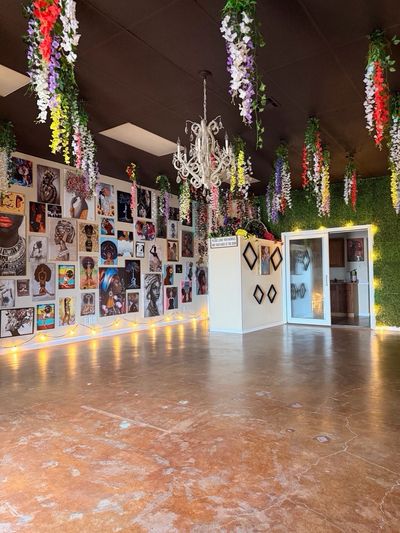 Art gallery with hanging flowers and vibrant wall art.