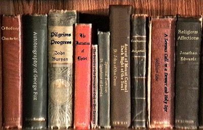 A row of old religious and spiritual books on a shelf.