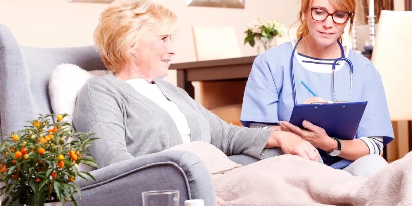 Nurse caring for elderly woman at home.