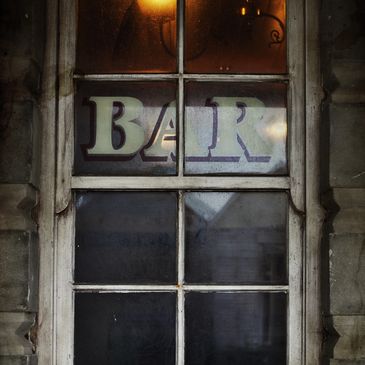 Old window with a faded 'BAR' sign.