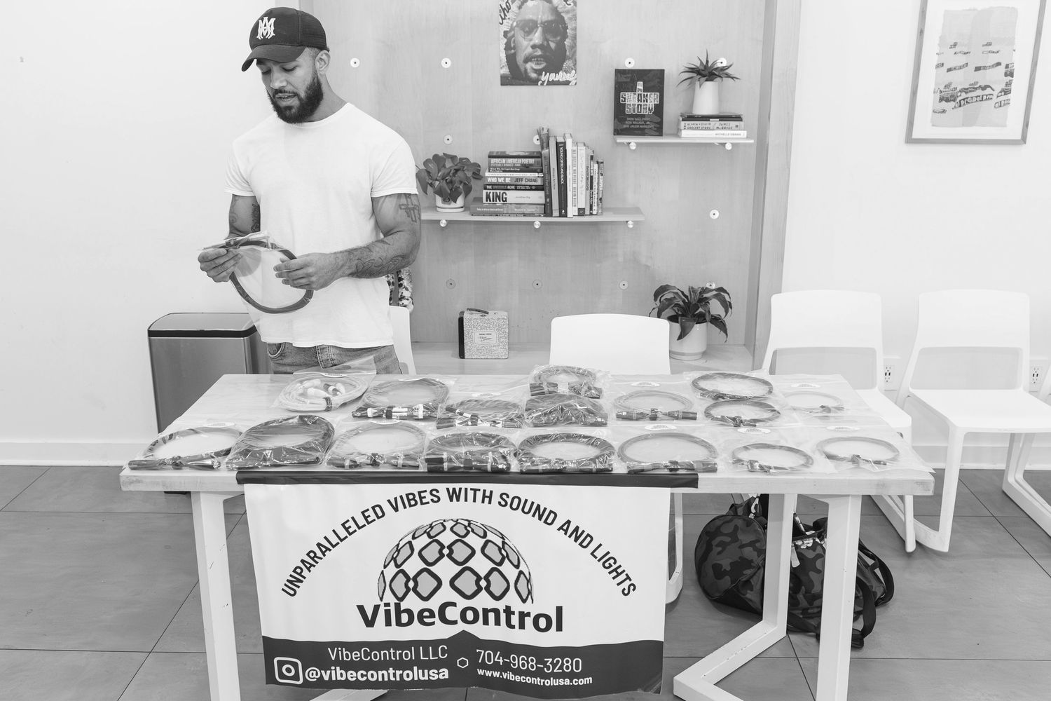 A man showcasing VibeControl sound and light devices at a display table.