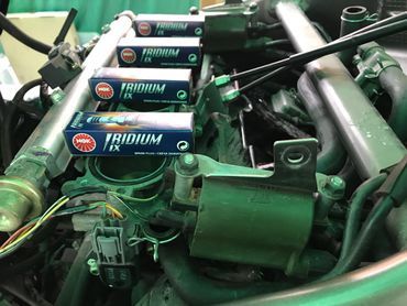 Iridium NGK spark plugs on top of an engine