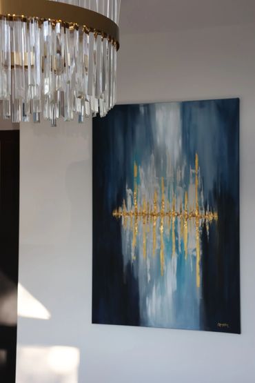 Modern gold and glass chandelier matching abstract artwork white, blue , navy and gold canvas.