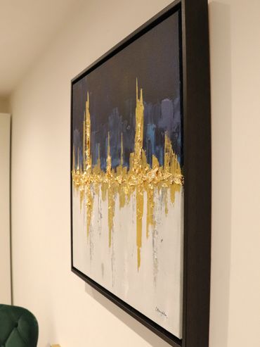 close up of black framed abstract artwork  with navy gold and white acrylic