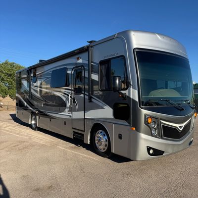 A large silver and black motorhome parked on a sunny day.