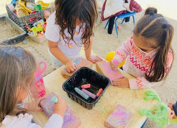 Group of kids playing with chalk sticks