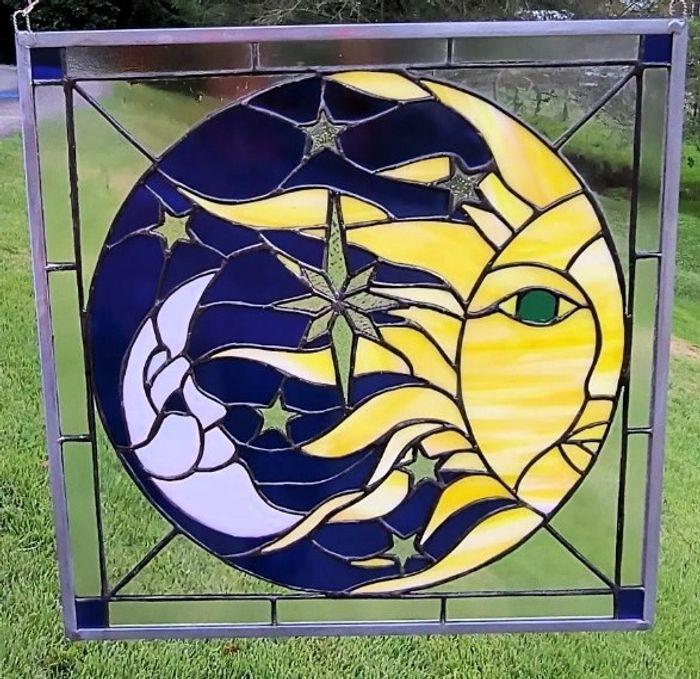 Stained Glass Sun and Moon with glowing yellows and blues with sparkling stars.