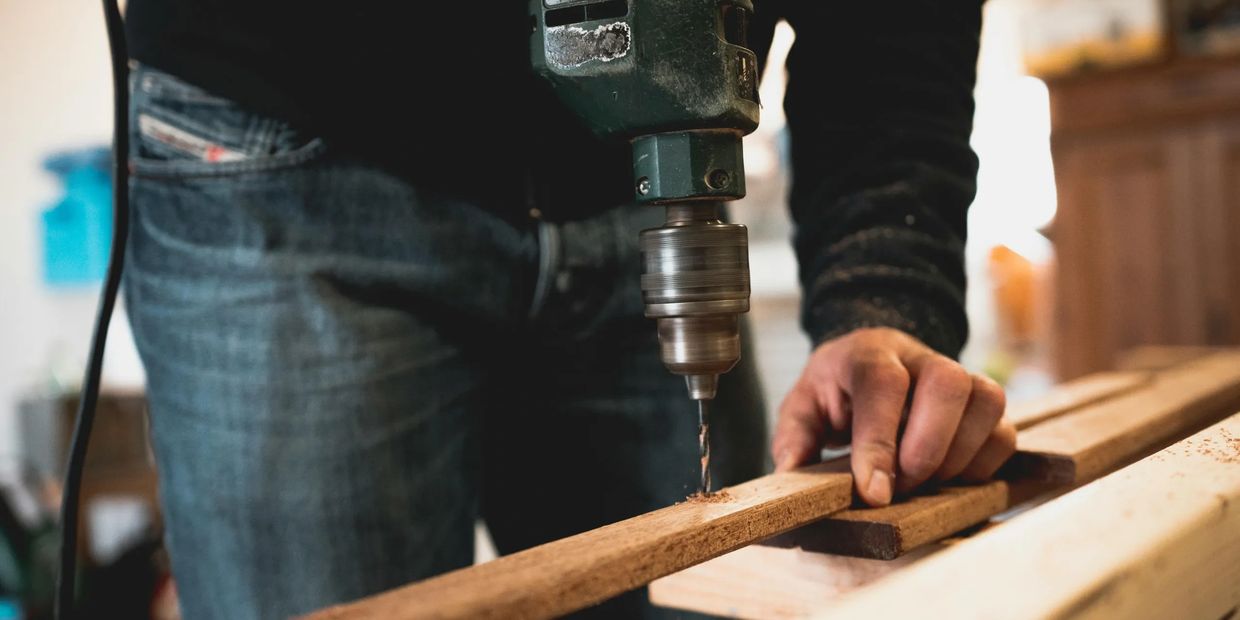 Construction worker drilling into wood 
