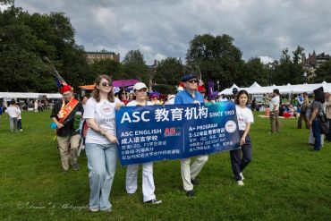 Group holding ASC education banner at outdoor event.