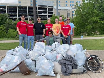 Group of people with the litter collected from Cottonwood Creek in Dallas, TX
