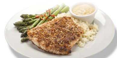 Crispy breaded fish fillet with asparagus, rice, and dipping sauce.