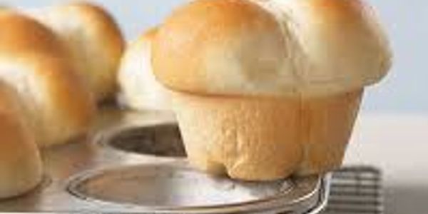 Freshly baked golden bread rolls cooling on a tray.
