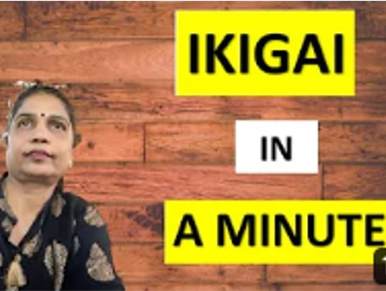 A woman presenting a video titled 'Ikigai in a Minute' with a wooden background.