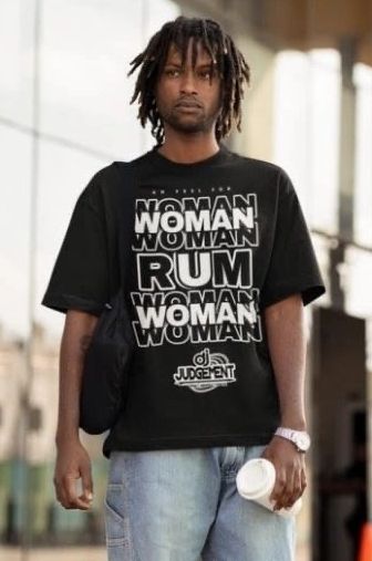 Man wearing a black graphic t-shirt with bold text, holding a coffee cup.