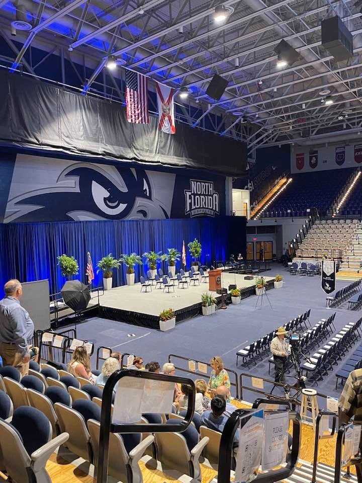 An indoor auditorium setup for an event with a stage and seating at North Florida.