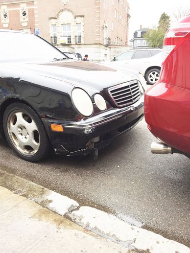 Two cars involved in a minor rear-end collision on a city street.
