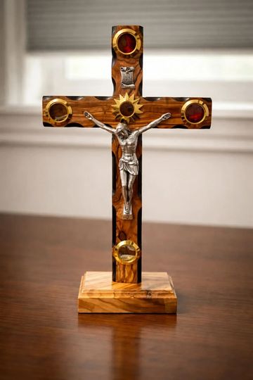 Wooden crucifix with metal Jesus figure and decorative circular accents.