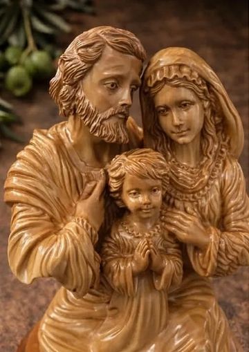 Wooden sculpture of a family with serene expressions.