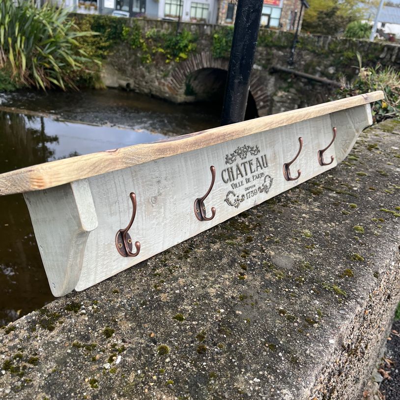 Wooden wall hook rack with five hooks.