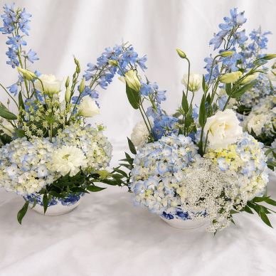 Elegant blue and white floral arrangements in delicate vases.