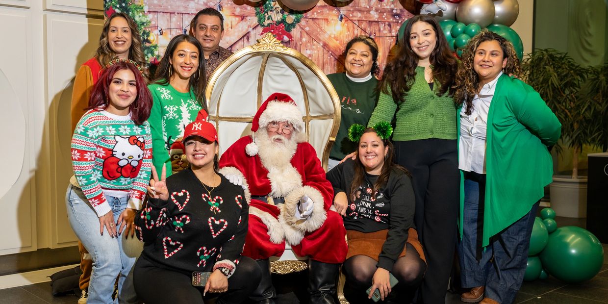 Group photo with Santa Claus at a festive holiday gathering.