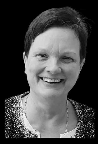 Smiling woman with short hair in black and white portrait.