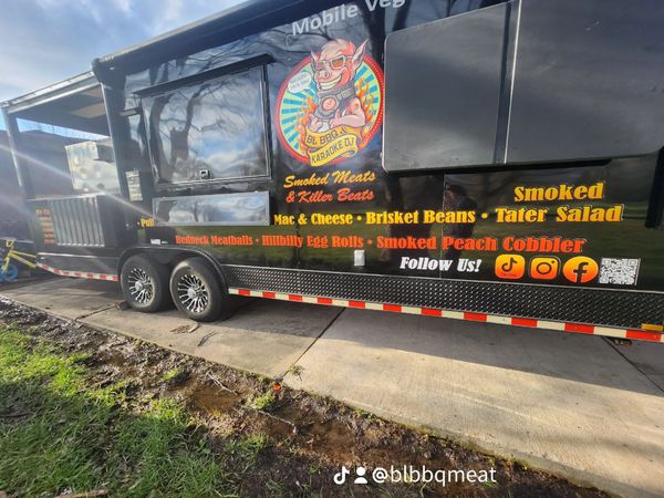 BBQ food truck with colorful signage and menu items.