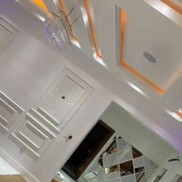Luxurious modern interior with geometric ceiling design and chandelier.