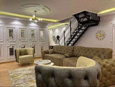 Modern living room with neutral tones and a spiral staircase.