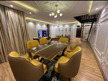 Modern dining room with yellow cushioned chairs and wooden table.