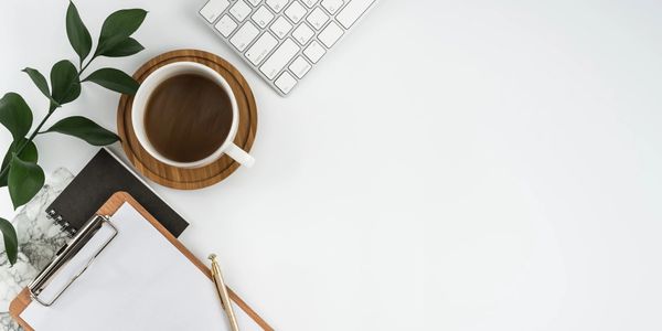 Coffe mug next to a clip board