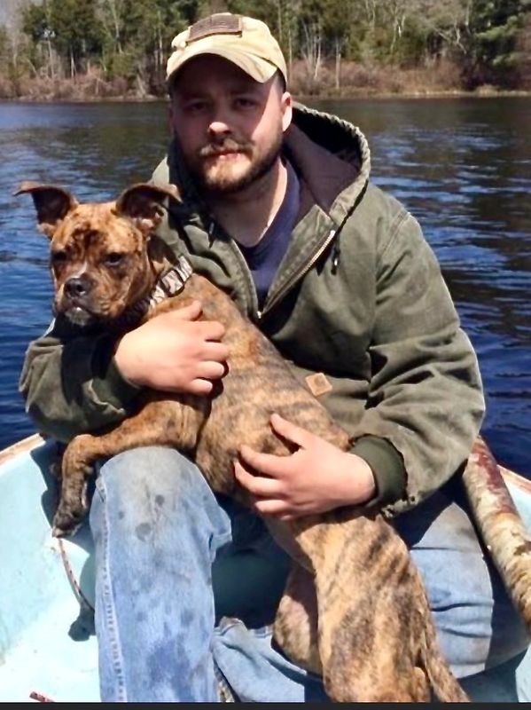 Photo oBruce Cardenas (APG CEO) and his rescue dog, Dixie, on a rowboat on a lake.