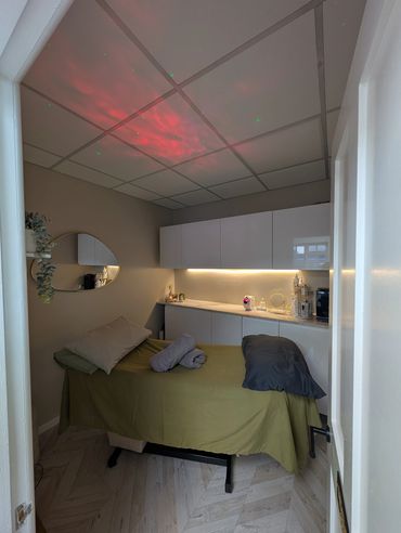 Cozy massage room with soft lighting and neatly arranged towels.