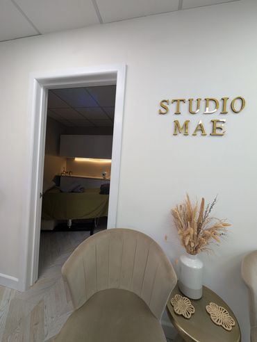 Cozy interior of Studio Mae with seating and a treatment room.