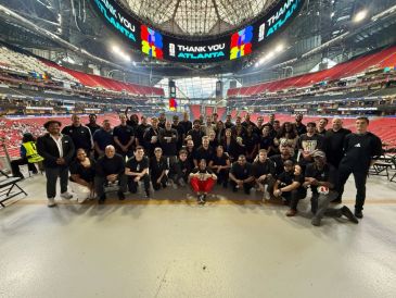 Group photo of a large team inside a stadium.