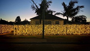 Bright commercial grade fairy lights along fences for home wedding.
