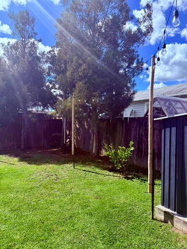Festoon lighting strung between poles, creating simple outdoor ambient lighting across the space.