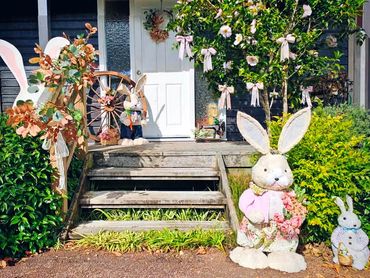 Easter bunny family and farmhouse style seasonal decor on front porch for Easter gathering.