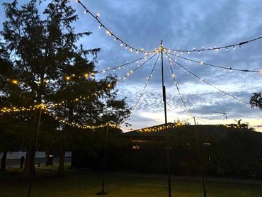 Fairy lights canopy, creating warm overhead canopy lighting across an outdoor space.