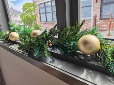 Greenery garland with gold baubles and subtle accents styled along a window ledge.