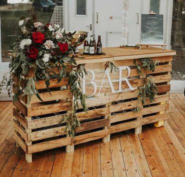 Greenery and floral styling with draped foliage accents, adding natural detail to a bar setup.