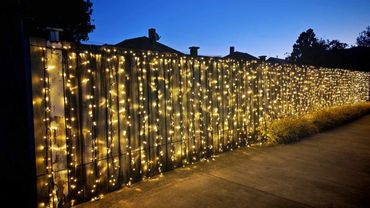 Bright commercial grade fairy lights along fences for home wedding.