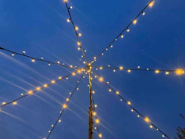 Fairy lights canopy, creating warm overhead canopy lighting across an outdoor space.